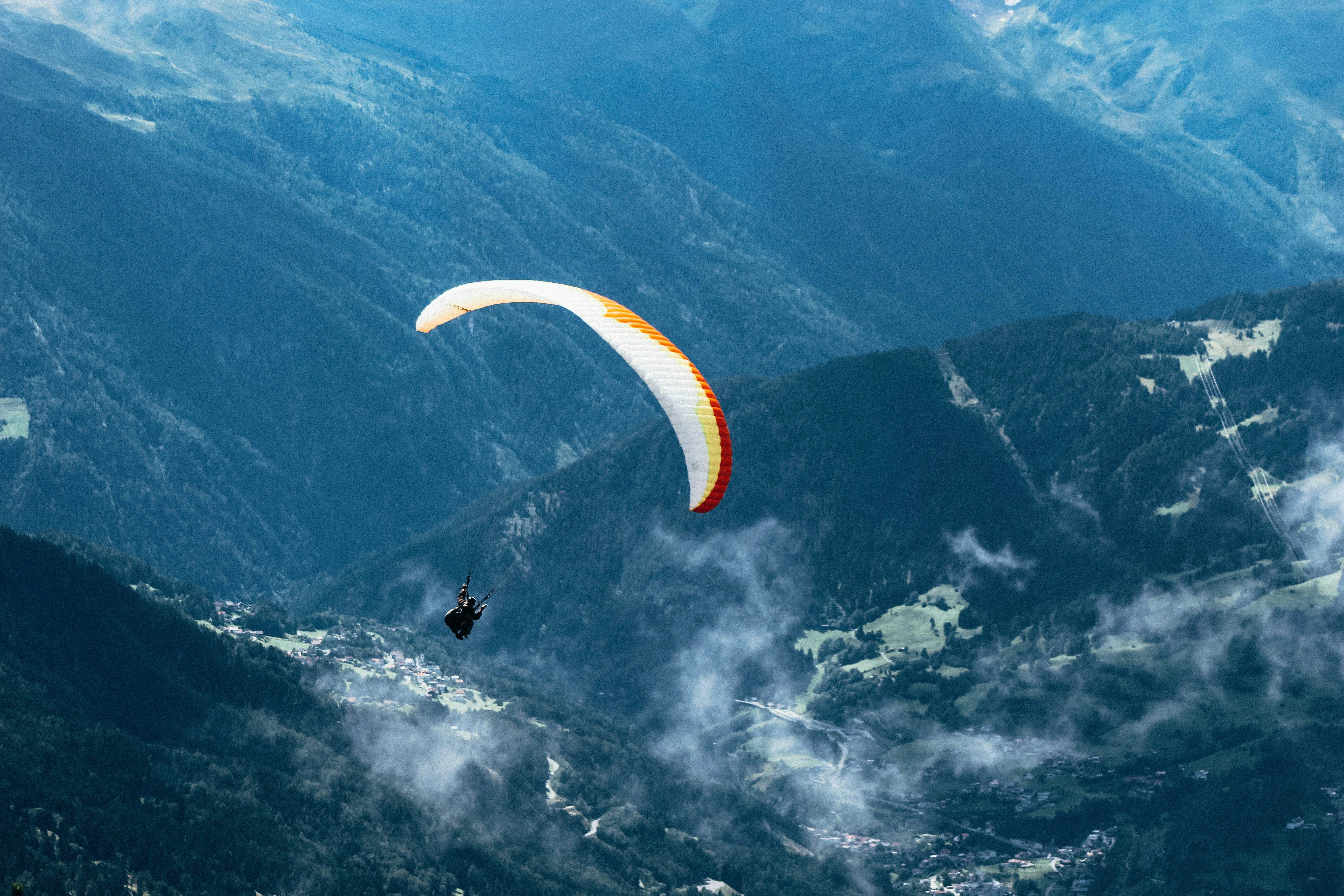 Tandem paragliding flight over the Alps with bright blue sky