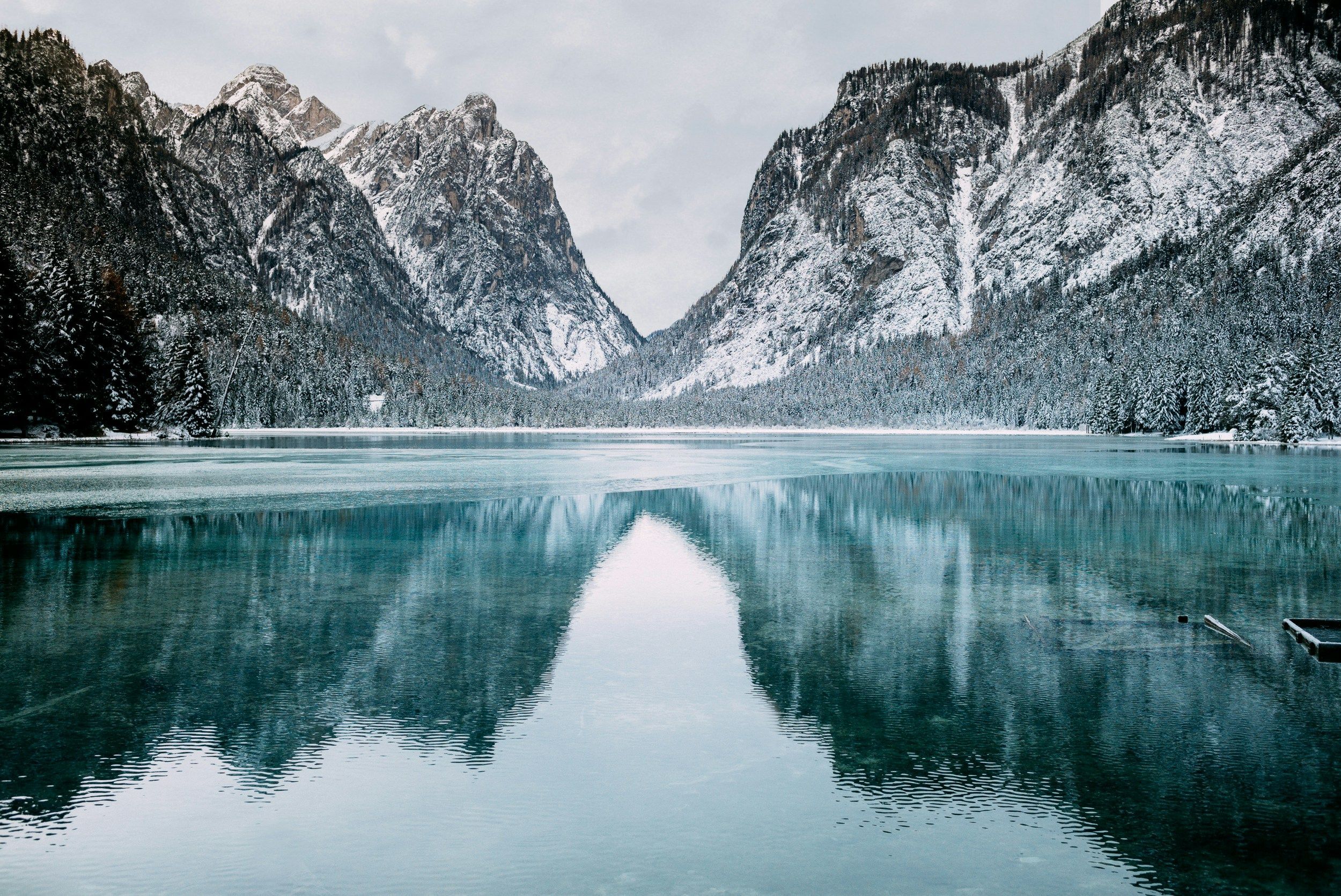 Panoramic view over alpine valleys, peaks, and lakes under a golden sunrise