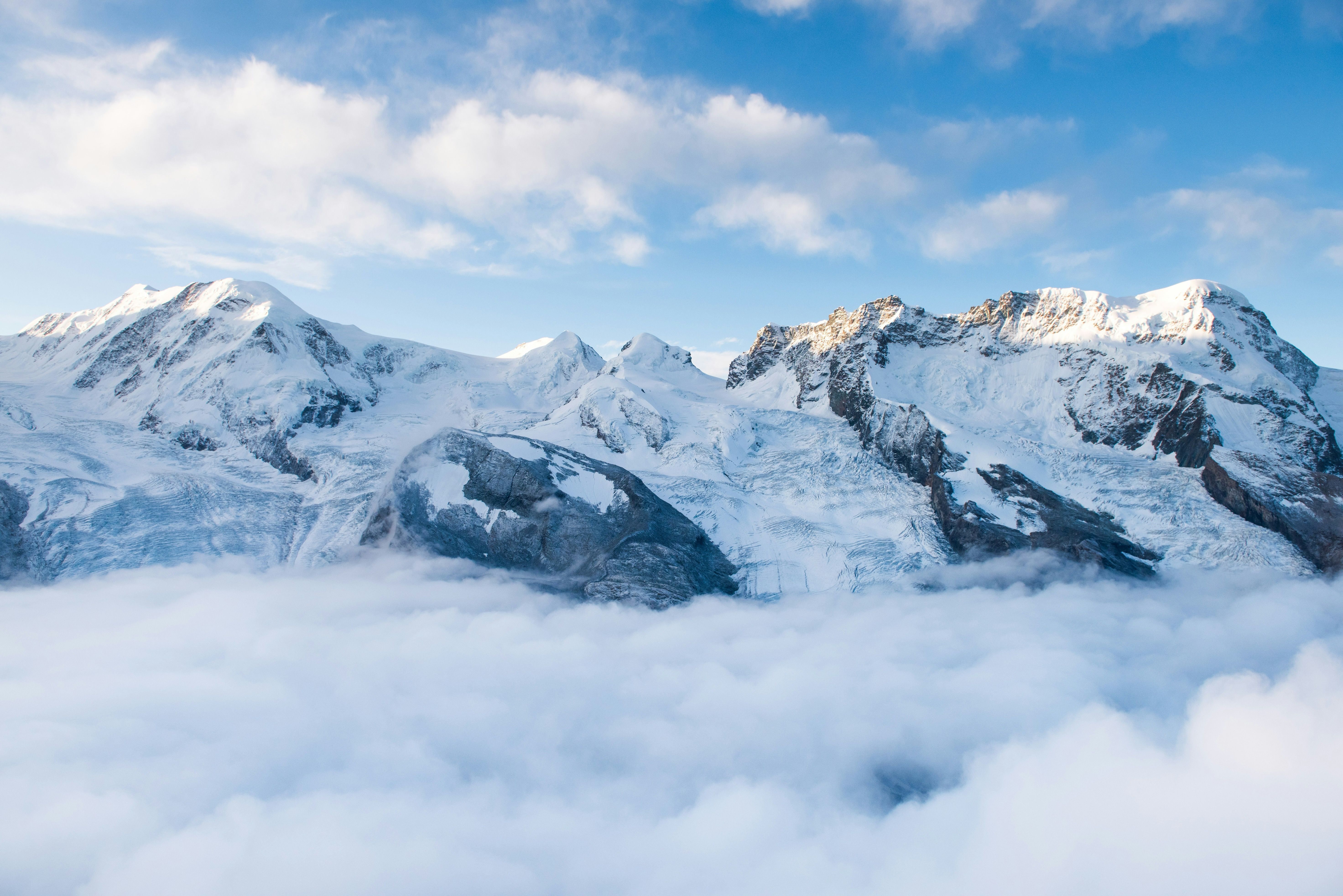 Snowy alpine ridge at sunrise with distant peaks